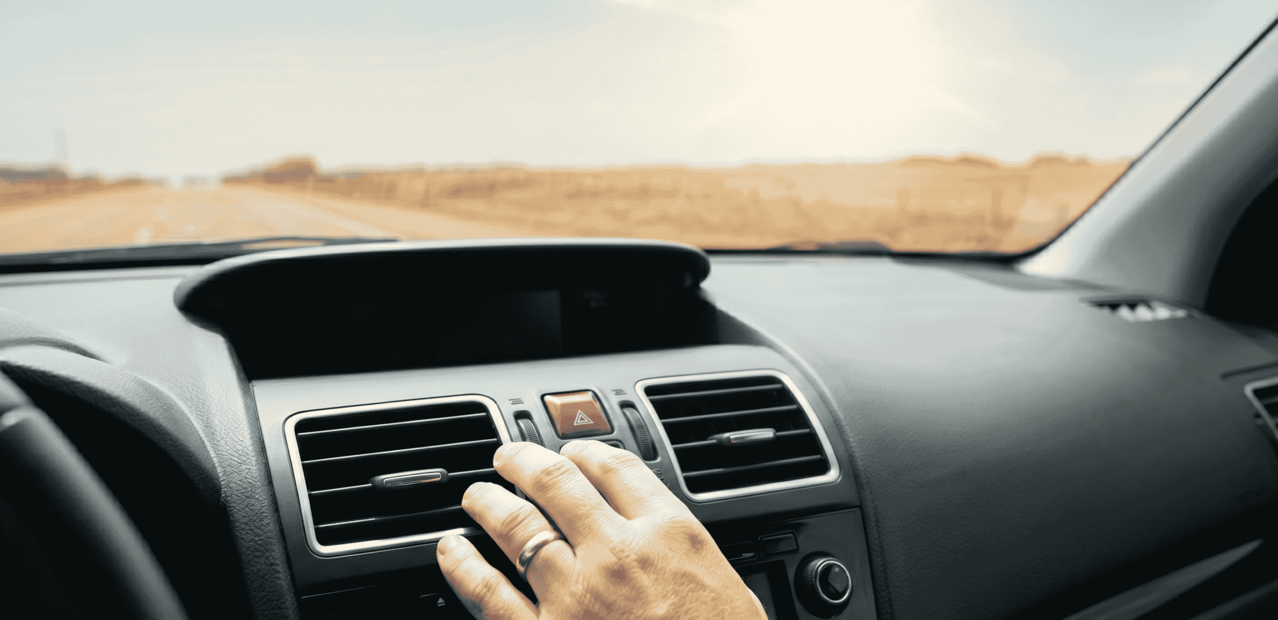 A man's hand adjusting the air vents in his car.