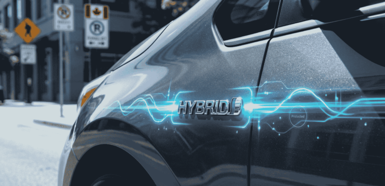 a close-up shot of the side of a grey car with the word 'hybrid' labeled on the car.
